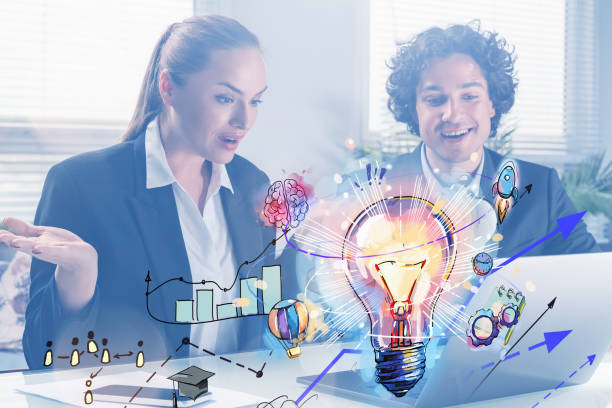 Surprised businessman and businesswoman looking into laptop display to find new ideas for start up. Colorful digital hologram of light bulb. Concept of creativity and brainstorming