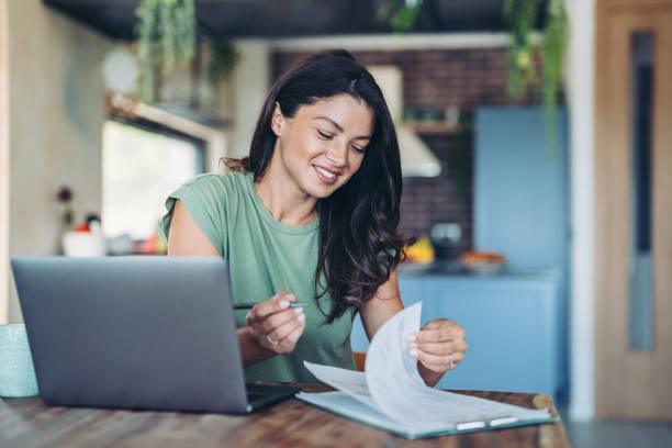 Smiling woman with laptop and documents