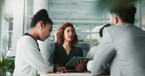 Woman, lawyer and tablet at meeting with team, planning and discussion for review for legal case in office. People, attorney and digital touchscreen with group, negotiation and feedback at law firm