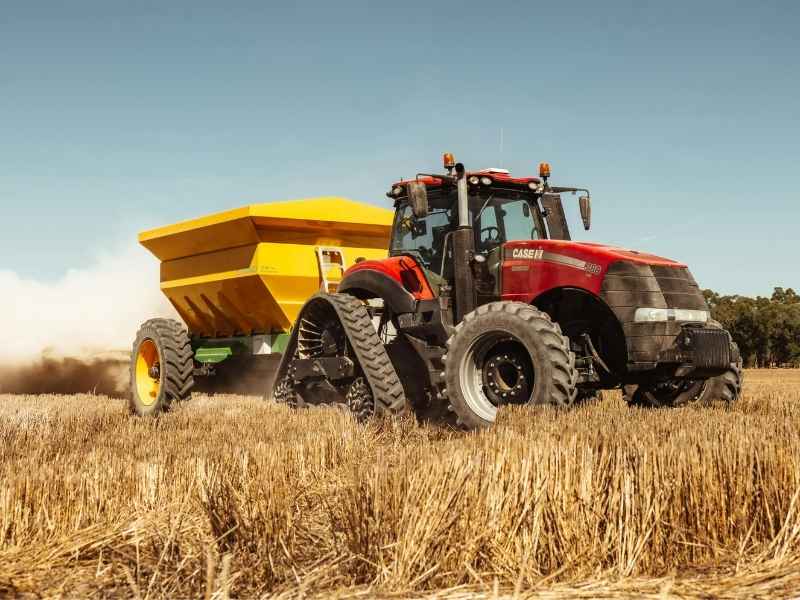 Modern tractor working on a dry agricultural field, symbolizing climate impacts on food production and the need for resilient farming practices.