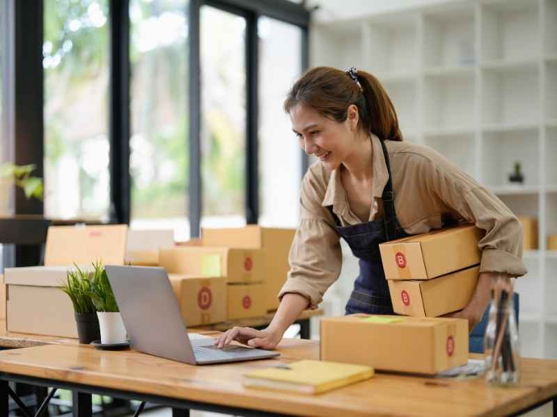 Entrepreneur managing online orders and logistics in a small business workspace
