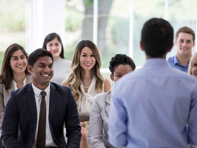 Group of motivated professionals attending a business presentation and exchanging ideas in a collaborative environment