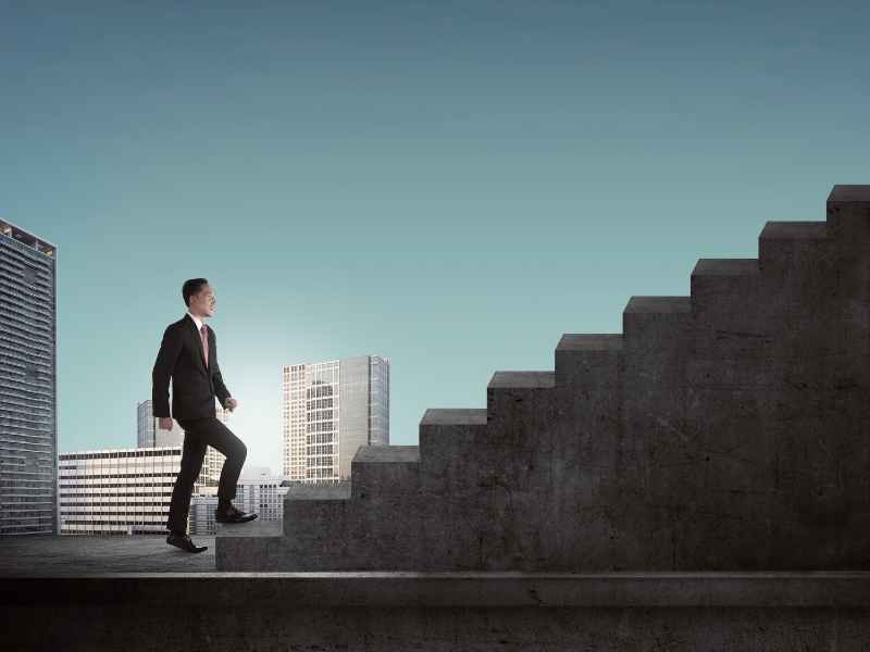 Business professional climbing steps representing career growth, personal development, and long-term success