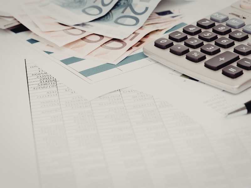 Financial documents with a calculator and cash, representing budgeting and multi-year forecasting.