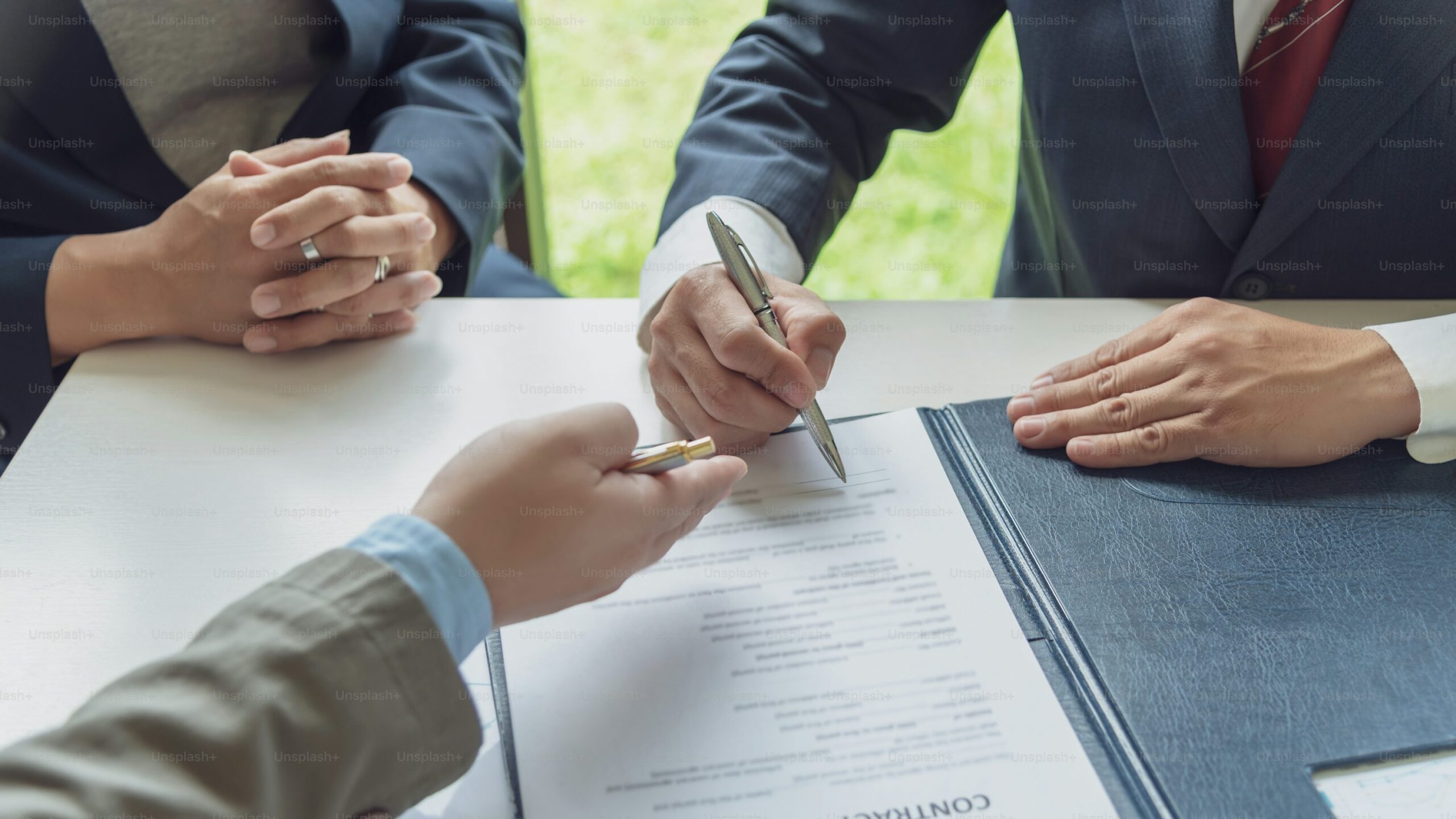 Business professionals signing a licensing agreement for the use and distribution of copyrighted content