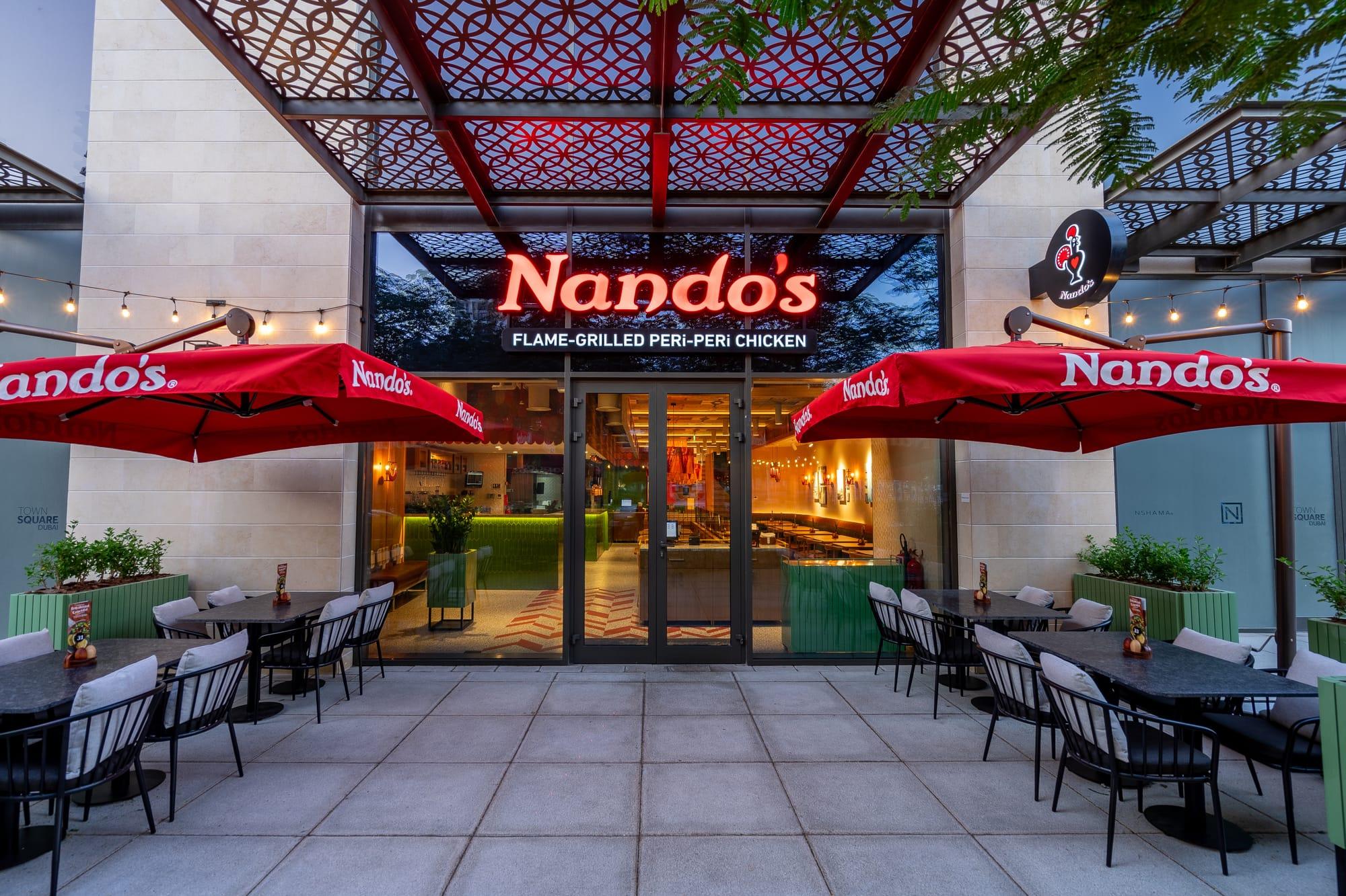 Modern restaurant exterior with outdoor seating and customers, illustrating the development of new restaurant locations.